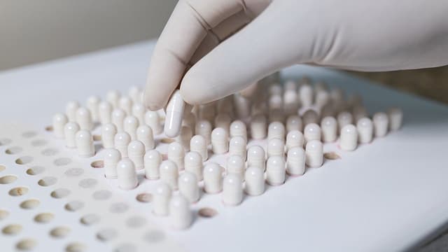 making white capsules. compounding pharmacy. compounding green medication. | Image Credit: © J. Balla Photography - © J. Balla Photography - stock.adobe.com