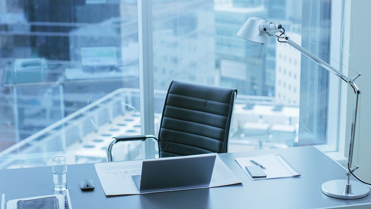 High Angle Shot of a Working Desk of a Successful Person in Office with Cityscape Window View. | Image Credit: © Gorodenkoff - stock.adobe.com