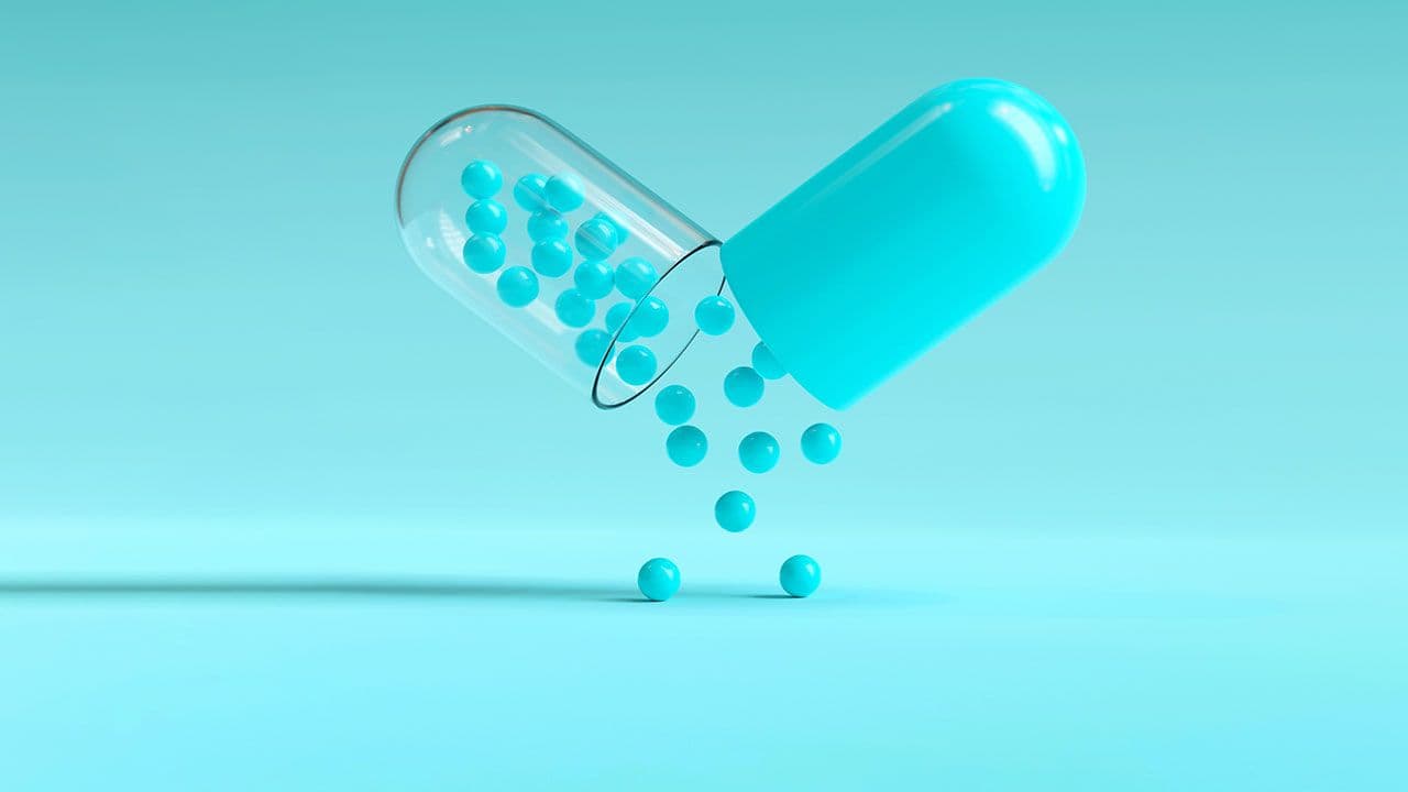 Capsule with granules background with copy space, can be used as medical mockup, template. 3D Rendering | Image Credit: ©Waseem Ali Khan - stock.adobe.com