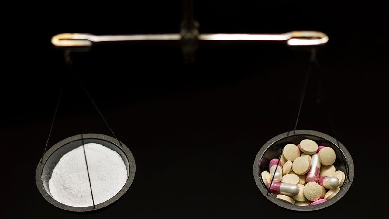 balance scale with pills| Image Credit: ©Alexander - Stock.adobe.com