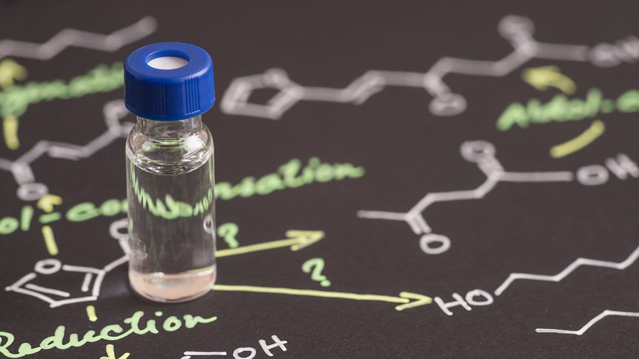 rueangwit/Stock.Adobe.com – biologic vial sitting atop molecular illustrations, conceptual analysis of protein therapeutic structure