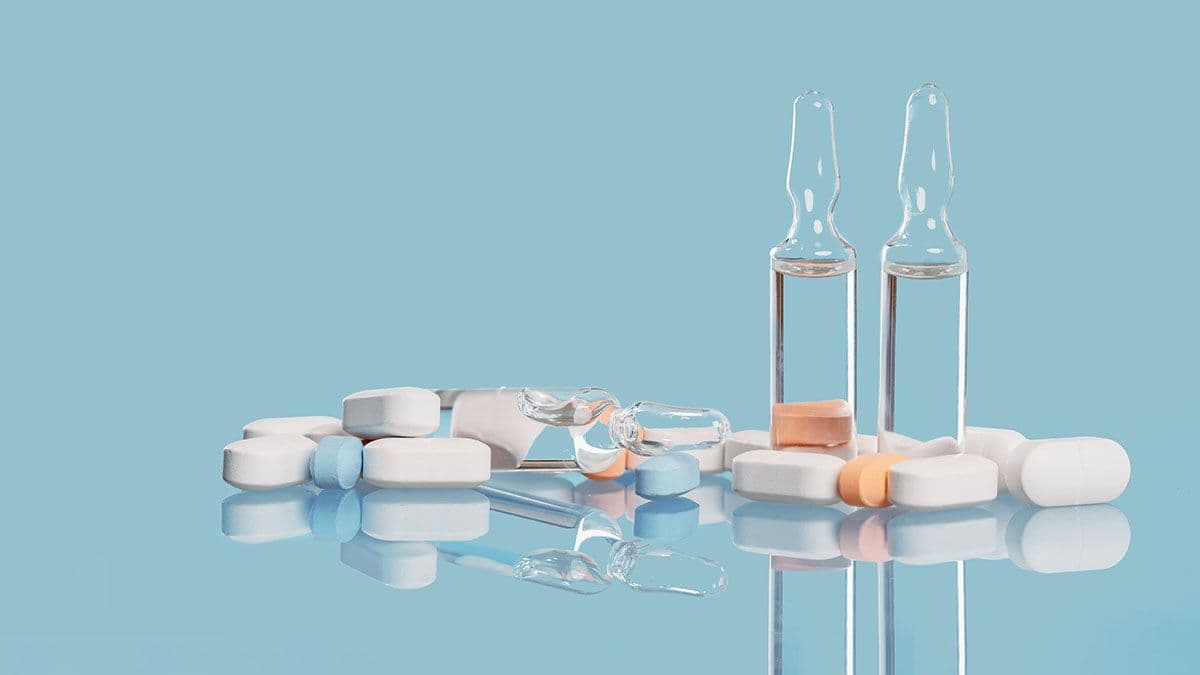 Medical background. many capsule tablets or pills on blue table. Glass vials. Vaccine. Close up. Healthcare pharmacy and medicine concept with copy space Painkillers or prescription drugs consumption | Image Credit: ©taniasv - stock.adobe.com